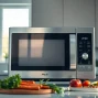 Showcase a modern microwave oven preparing fresh ingredients in a well-lit kitchen.